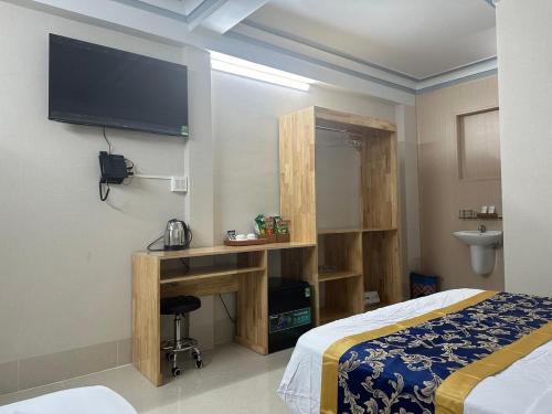 a bedroom with a bed and a tv on the wall at Khách Sạn The Second in Thốt Nốt