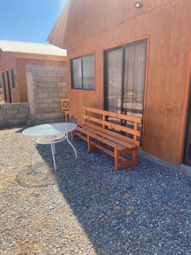 a picnic table and a bench next to a building at Cabañas La Fortaleza in Vicuña