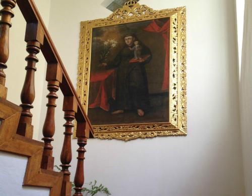 a painting of a woman with a dog on a staircase at Hostal & Apartments El Triunfo in Cusco