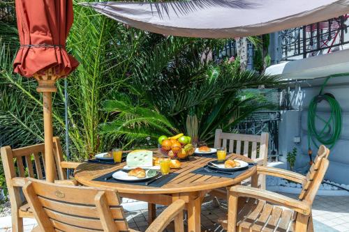 - une table en bois avec une assiette de fruits dans l'établissement Pelige 5 YourHostHelper, à Cannes