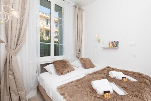- une chambre blanche dotée d'un lit avec oreillers et d'une fenêtre dans l'établissement Pelige 5 YourHostHelper, à Cannes