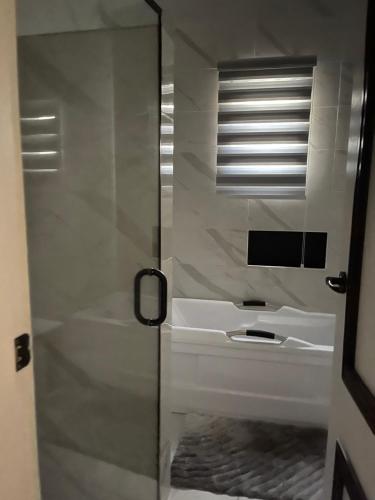 a bathroom with a sink and a glass shower door at Gorgeous 4 Bedrooms Single Family Home at Ibeju, Lekki Lagos in Lekki