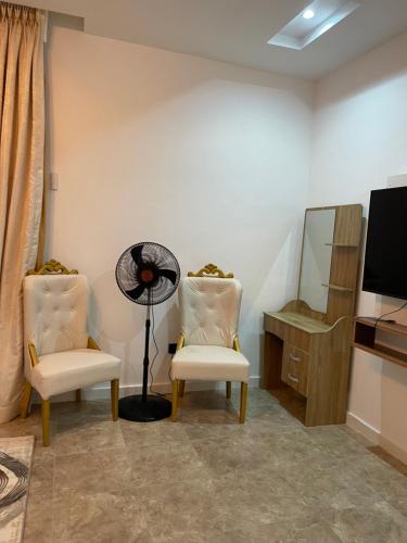 a room with two chairs and a fan and a television at Gorgeous 4 Bedrooms Single Family Home at Ibeju, Lekki Lagos in Lekki