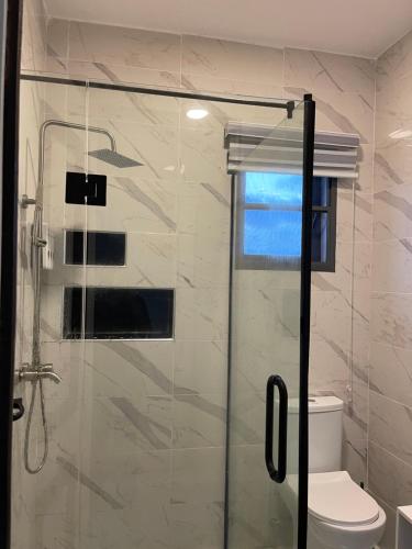 a bathroom with a glass shower with a toilet at Gorgeous 4 Bedrooms Single Family Home at Ibeju, Lekki Lagos in Lekki