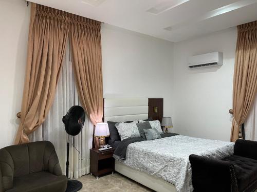 a bedroom with a bed and a chair at Gorgeous 4 Bedrooms Single Family Home at Ibeju, Lekki Lagos in Lekki