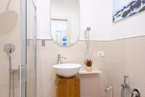 a bathroom with a white sink and a shower at Eos affittacamere in Castelsardo