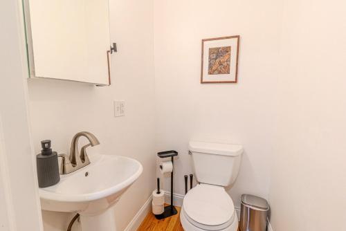 a white bathroom with a sink and a toilet at 4BDR Near Tufts-10min-Walk to Subway-Free Parking in Somerville