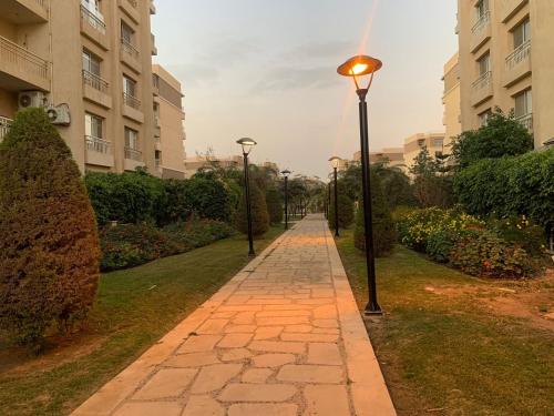 a street with street lights on a sidewalk at Casa De Madinaty -مدينتي in Madinaty