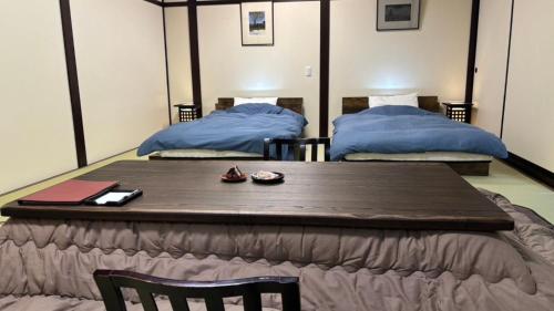 a table in a room with two beds at Oyado Koto No Yume in Takayama