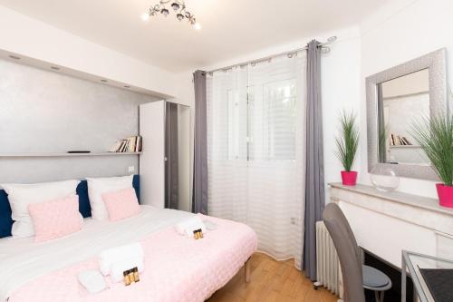 une chambre avec un lit, un bureau et un miroir dans l'établissement Pelige 3 YourHostHelper, à Cannes