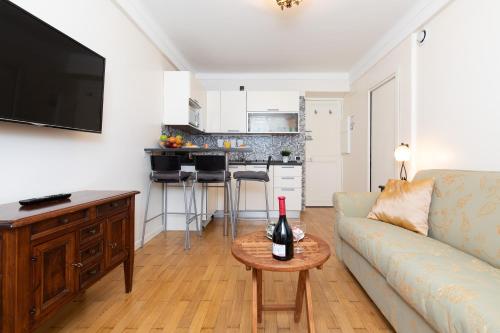 - un salon avec un canapé et une table avec une bouteille de vin dans l'établissement Pelige 3 YourHostHelper, à Cannes