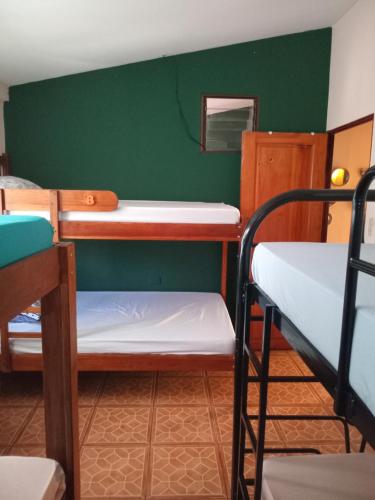 a room with two bunk beds and a green wall at Hospedaje Beliz Cambalache in Liberia