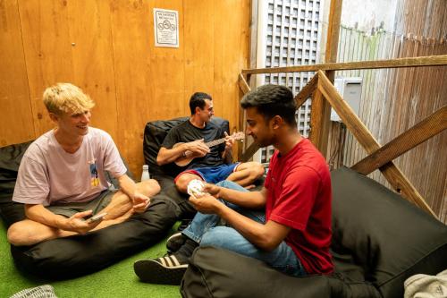 a group of men sitting on bean bags playing a video game at Urban Nomad Potts Point - 18 to 39 only in Sydney