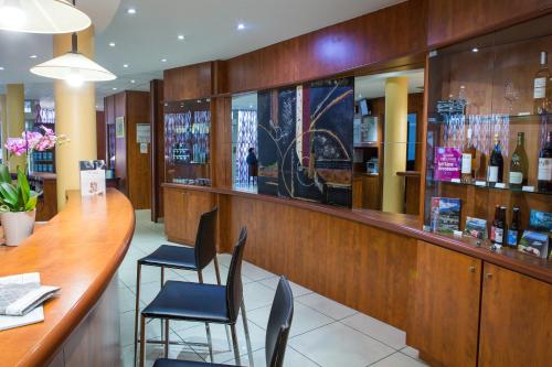a bar in a restaurant with chairs and bottles of wine at Mercure Béziers in Béziers