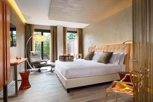 1 dormitorio con 1 cama blanca grande y escritorio en Milan Suite Hotel, en Milán