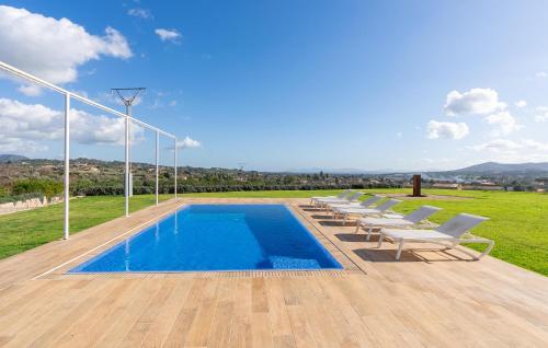 a row of chairs and a swimming pool on a deck at Cas Jurat De Selva in Selva