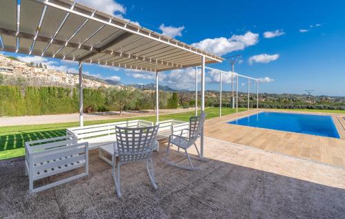 a patio with two chairs and a table and a pool at Cas Jurat De Selva in Selva
