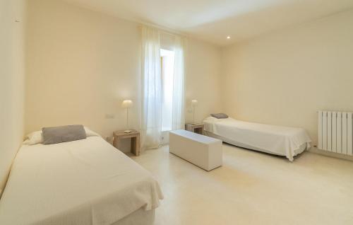 a white room with two beds and a window at Cas Jurat De Selva in Selva