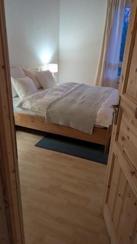 a bedroom with a bed and a window and a door at Casa14 - Swiss houses in Steffisburg