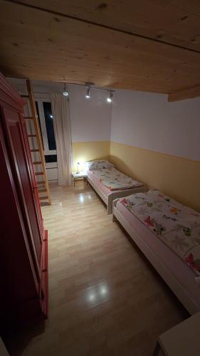 a room with two beds and a staircase in it at Casa14 - Swiss houses in Steffisburg