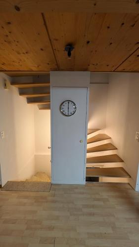 a room with a white door with a clock on it at Casa14 - Swiss houses in Steffisburg