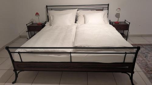 a bed with white sheets and pillows in a bedroom at Casa14 - Swiss houses in Steffisburg