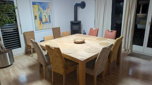a dining room table with chairs and a wooden table and a table at Casa14 - Swiss houses in Steffisburg