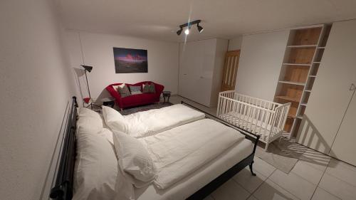 a hospital bed in a room with a red chair at Casa14 - Swiss houses in Steffisburg