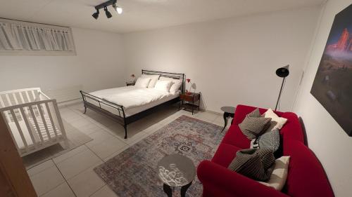 a living room with a bed and a red couch at Casa14 - Swiss houses in Steffisburg