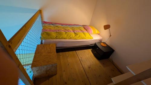 a small bedroom with a bed and a lamp at Casa14 - Swiss houses in Steffisburg