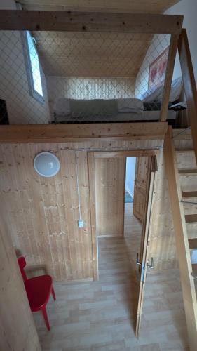 a small room with a bed and a red chair at Casa14 - Swiss houses in Steffisburg