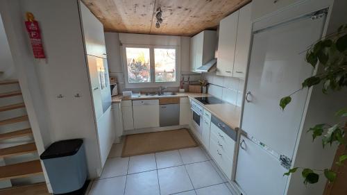 a small kitchen with white cabinets and a window at Casa14 - Swiss houses in Steffisburg