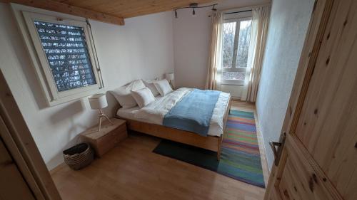 a bedroom with a bed in a room with a window at Casa14 - Swiss houses in Steffisburg