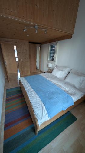 a bedroom with a large bed with a blue blanket at Casa14 - Swiss houses in Steffisburg