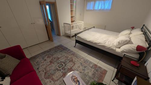 a bedroom with a bed and a couch and a rug at Casa14 - Swiss houses in Steffisburg