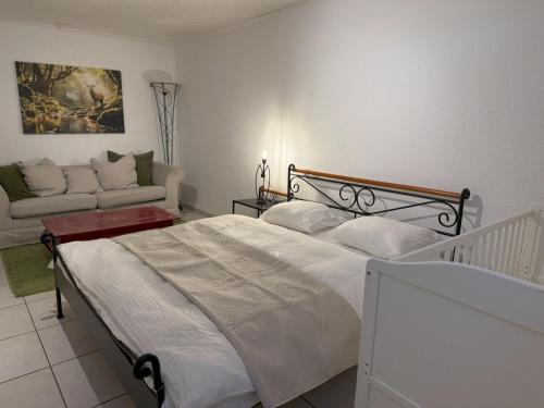 a bedroom with a large bed and a couch at Casa14 - Swiss houses in Steffisburg