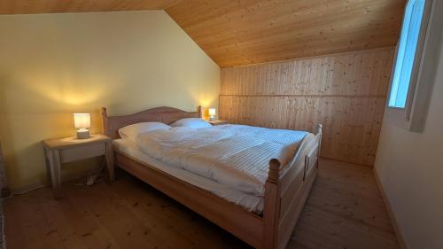 a bedroom with a bed and two lamps on two tables at Casa14 - Swiss houses in Steffisburg