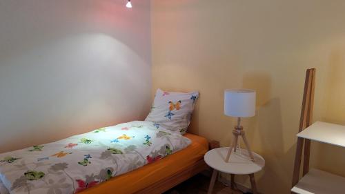 a small bedroom with a bed and a lamp at Casa14 - Swiss houses in Steffisburg