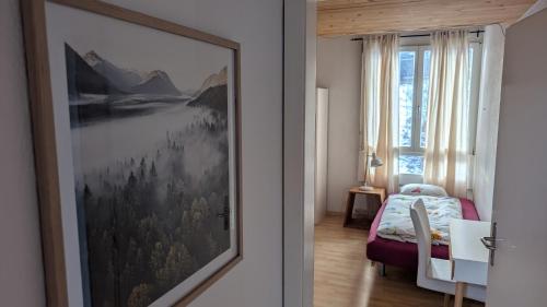 a bedroom with a painting on the wall next to a bed at Casa14 - Swiss houses in Steffisburg
