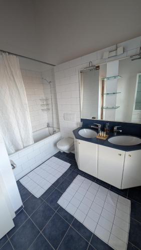 a bathroom with two sinks and a tub and a toilet at Casa14 - Swiss houses in Steffisburg