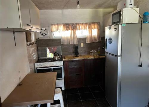 a small kitchen with a refrigerator and a stove at CASA PARA 10 PERSONAs in Aguas Dulces