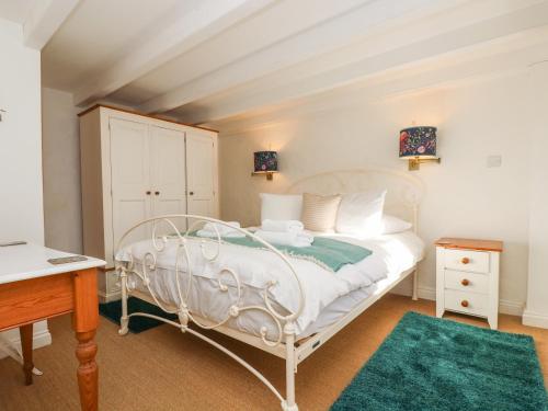 a bedroom with a white bed and a desk at Trehan in St Ives