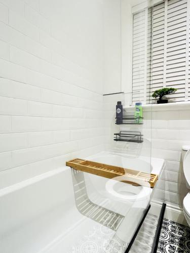 a white bathroom with a toilet and a bath tub at Ground Floor Entire Apartment Self Checkin in Crossgates