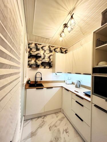 a kitchen with white cabinets and a sink at Ground Floor Entire Apartment Self Checkin in Crossgates