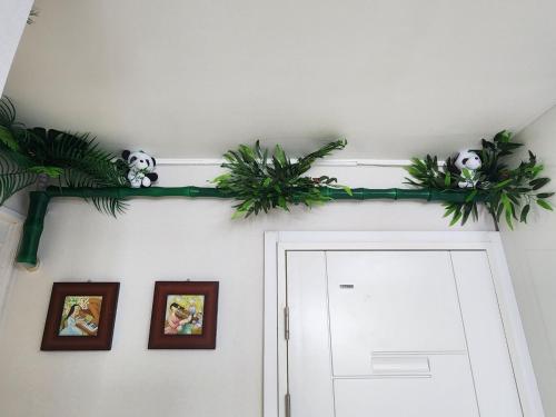 a room with a door with plants on the wall at House of Gallery Hyomok in Daegu