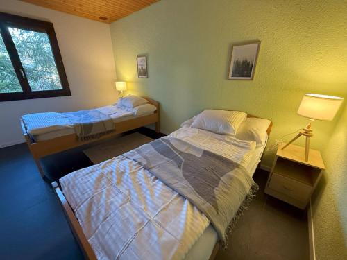 a room with two beds and a window at Casa14 - Swiss houses in Steffisburg