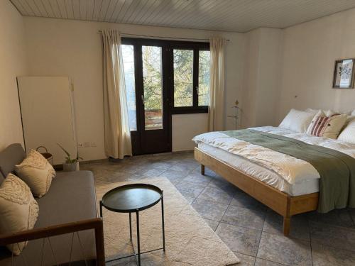 a bedroom with a large bed and a couch at Casa14 - Swiss houses in Steffisburg