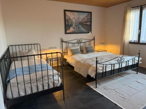 a bedroom with two beds and a window at Casa14 - Swiss houses in Steffisburg