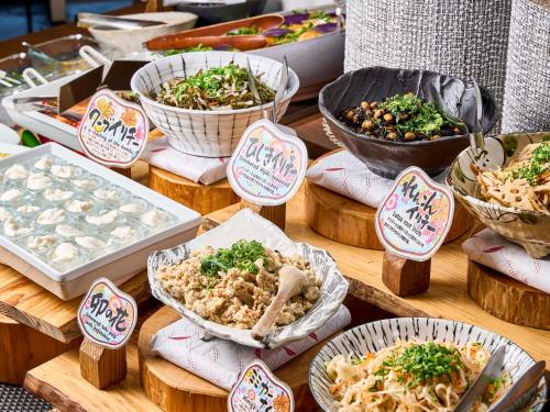 a table with bowls of food and plates of food at Daiwa Roynet Hotel Naha Kokusaidori in Naha