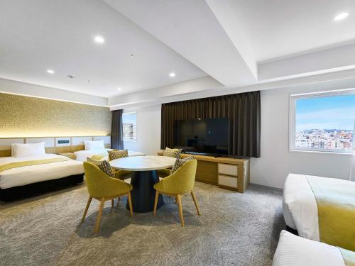 a hotel room with a bed and a table and chairs at Daiwa Roynet Hotel Naha Kokusaidori in Naha